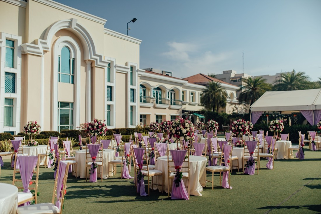 Styled outdoor reception tables with floral centerpieces by SGR Decorators